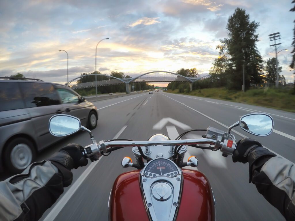 Riding a motorcycle during a vibrant sunset.